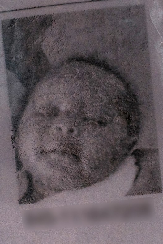 A black and white photograph of an infant on an ID card.