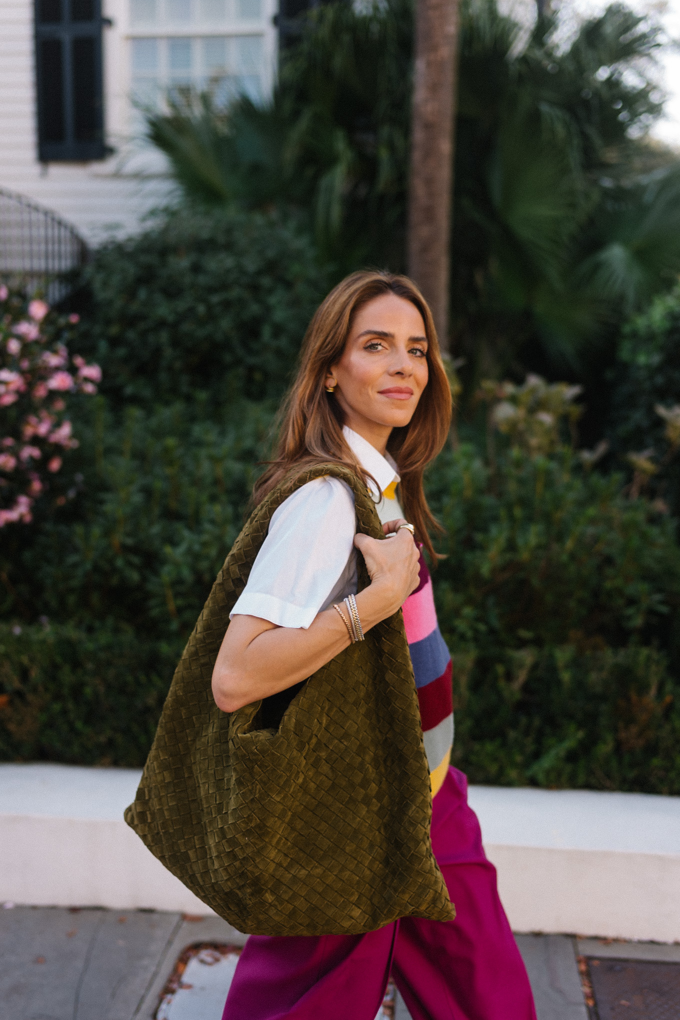 Gilet pull à rayures arc-en-ciel, pantalon en satin magenta, sac en daim vert
