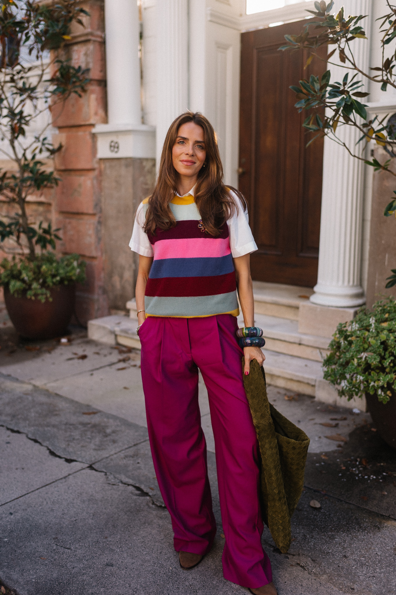 Gilet pull à rayures arc-en-ciel, pantalon en satin magenta, sac en daim vert