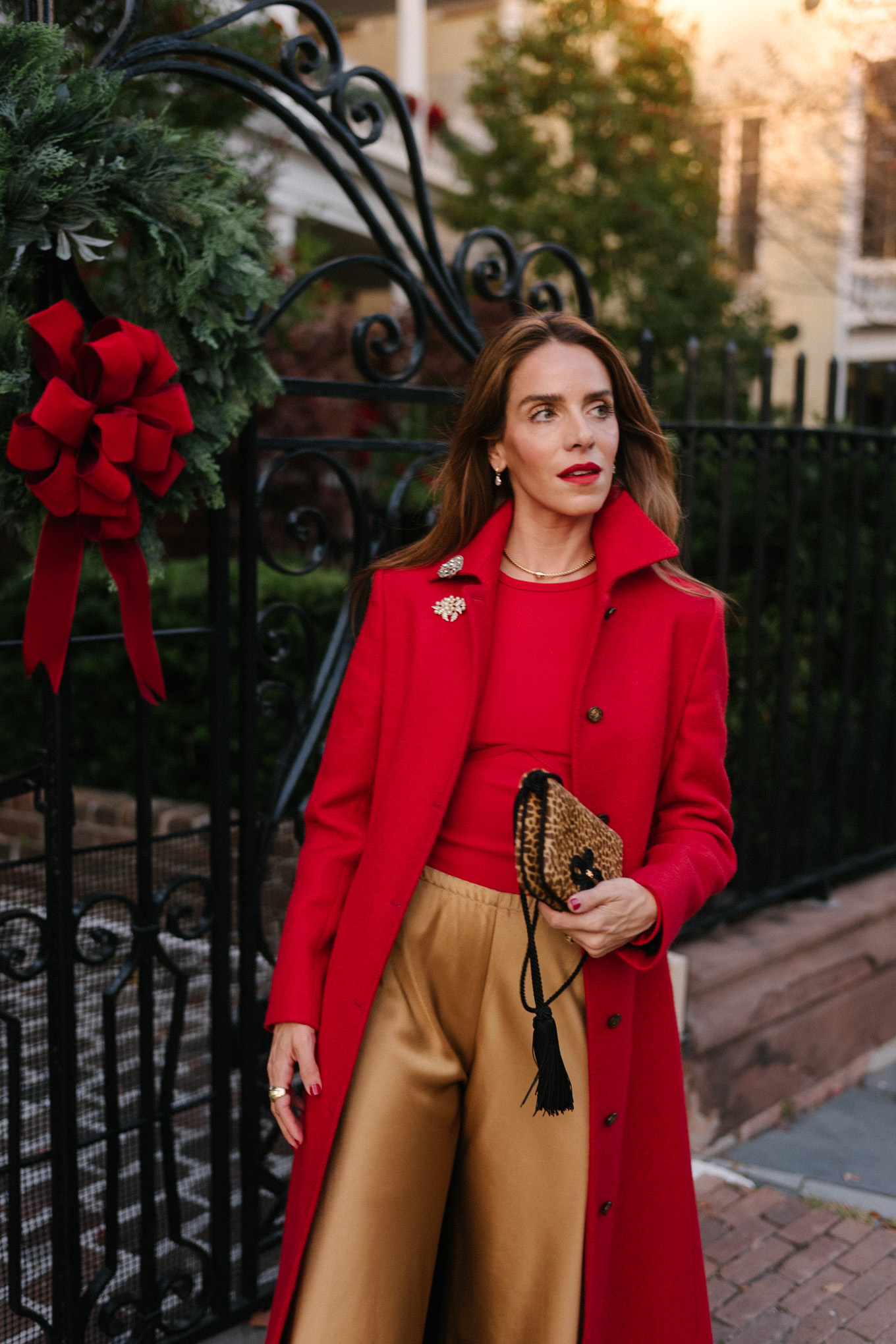 manteau en laine rouge, body rouge, pantalon en satin doré, sac à main léopard