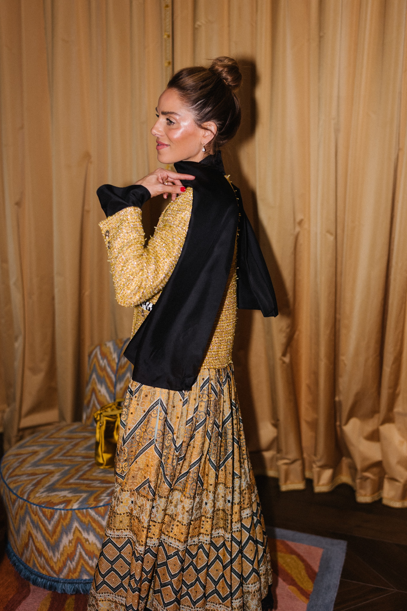 Veste en tweed doré, jupe imprimée dorée, sac seau en soie dorée, écharpe noire, bottes noires