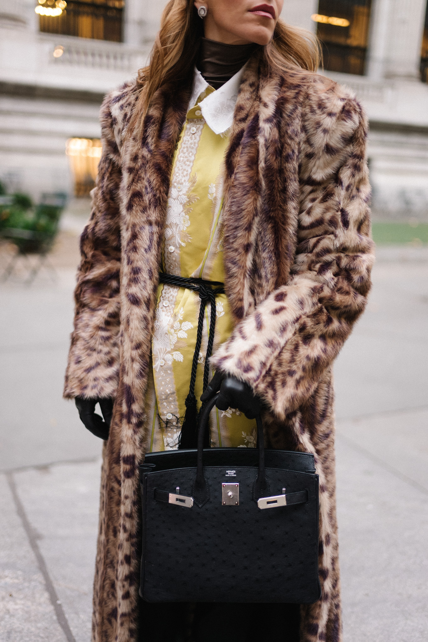 Manteau léopard, veste en soie, col roulé marron, ceinture à pompons, sac à main noir, gants noirs