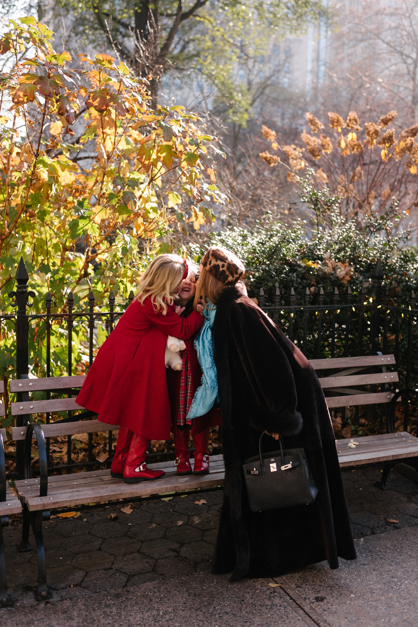 Manteau en peau lainée marron, chapeau casemate imprimé léopard, pantalon en satin vert, foulard en soie turquoise