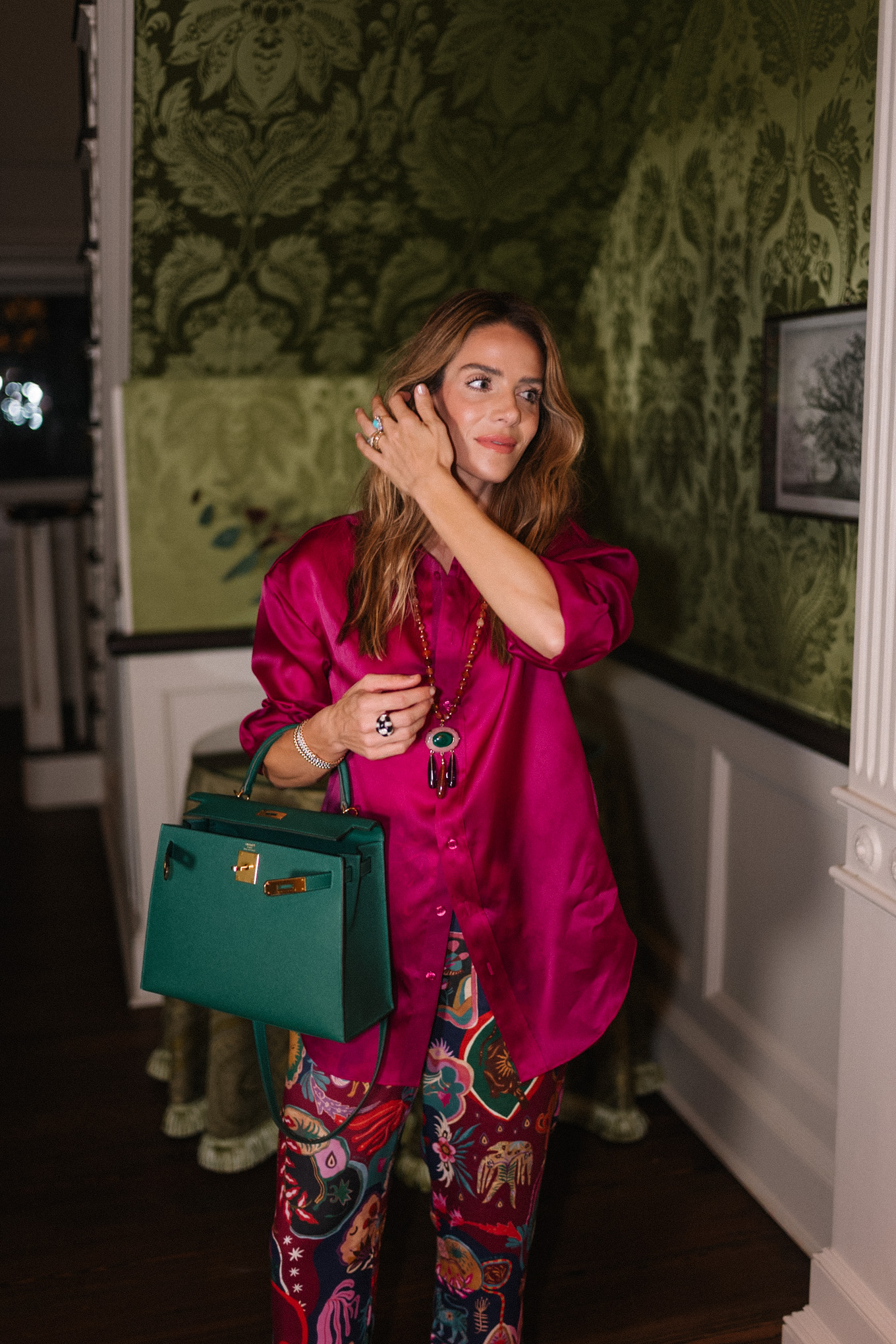 Blouse en soie magenta, pantalon à motifs en soie, sac à main vert