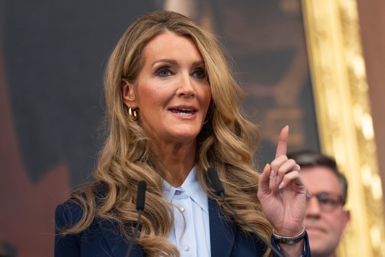 Une femme pointe un doigt vers le haut tout en parlant.