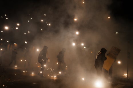 Des gens courent après que des agents fédéraux ont utilisé une grenade assourdissante lors d'une manifestation dans le comté de Hennepin, Minnesota, le 13 janvier 2026.