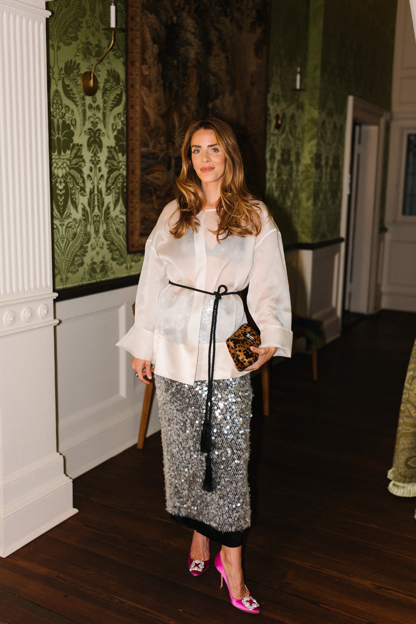 Blouse transparente blanche, jupe argentée scintillante, sac léopard, ceinture noire à pompon