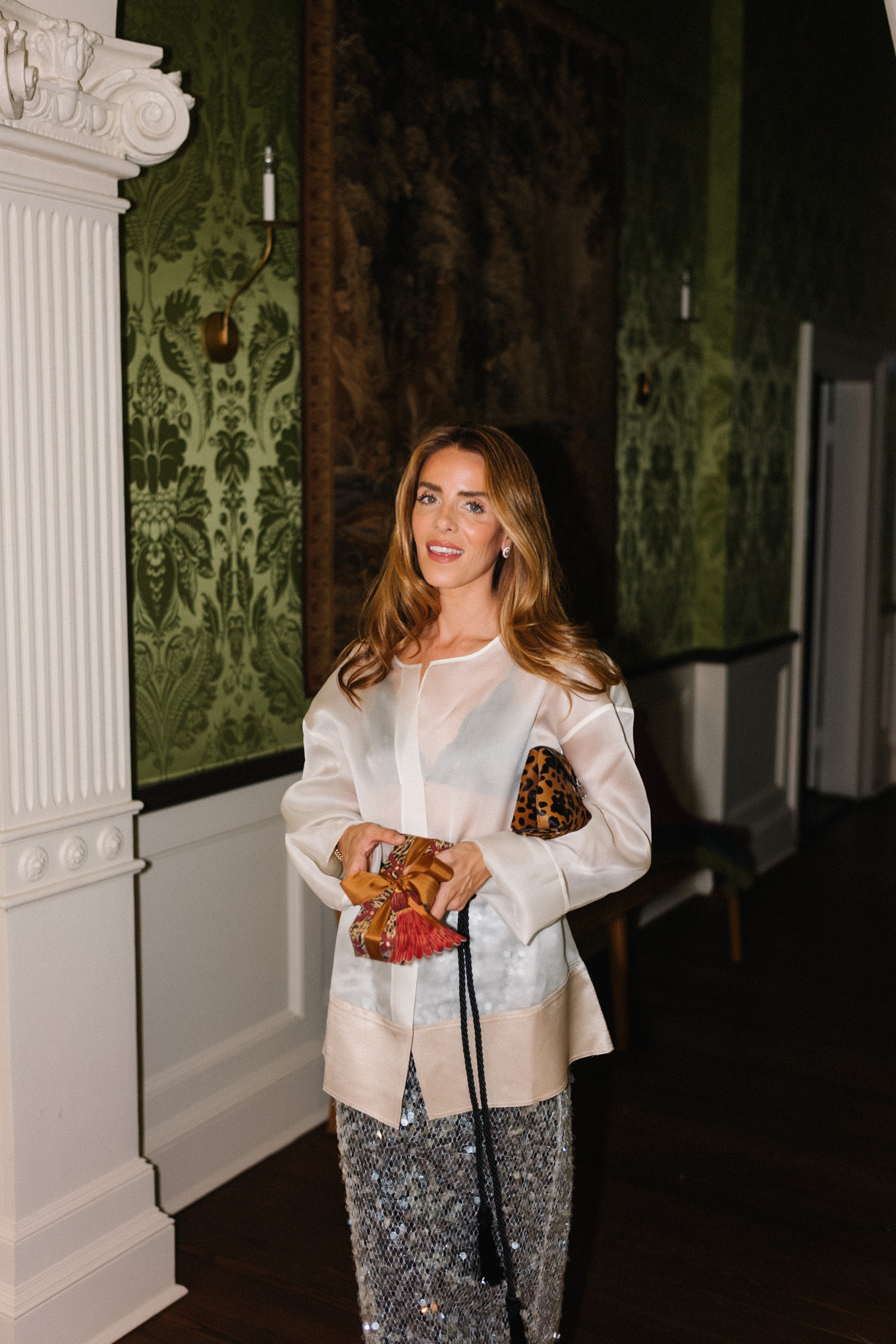 Blouse transparente blanche, jupe argentée scintillante, sac léopard, ceinture noire à pompon