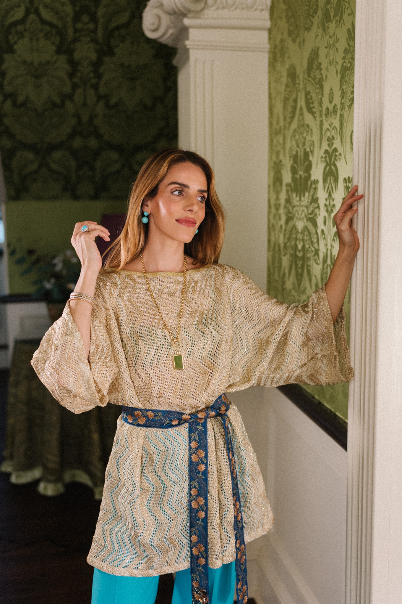 Haut en maille métallisée, pantalon en soie turquoise, ceinture à nouer en soie