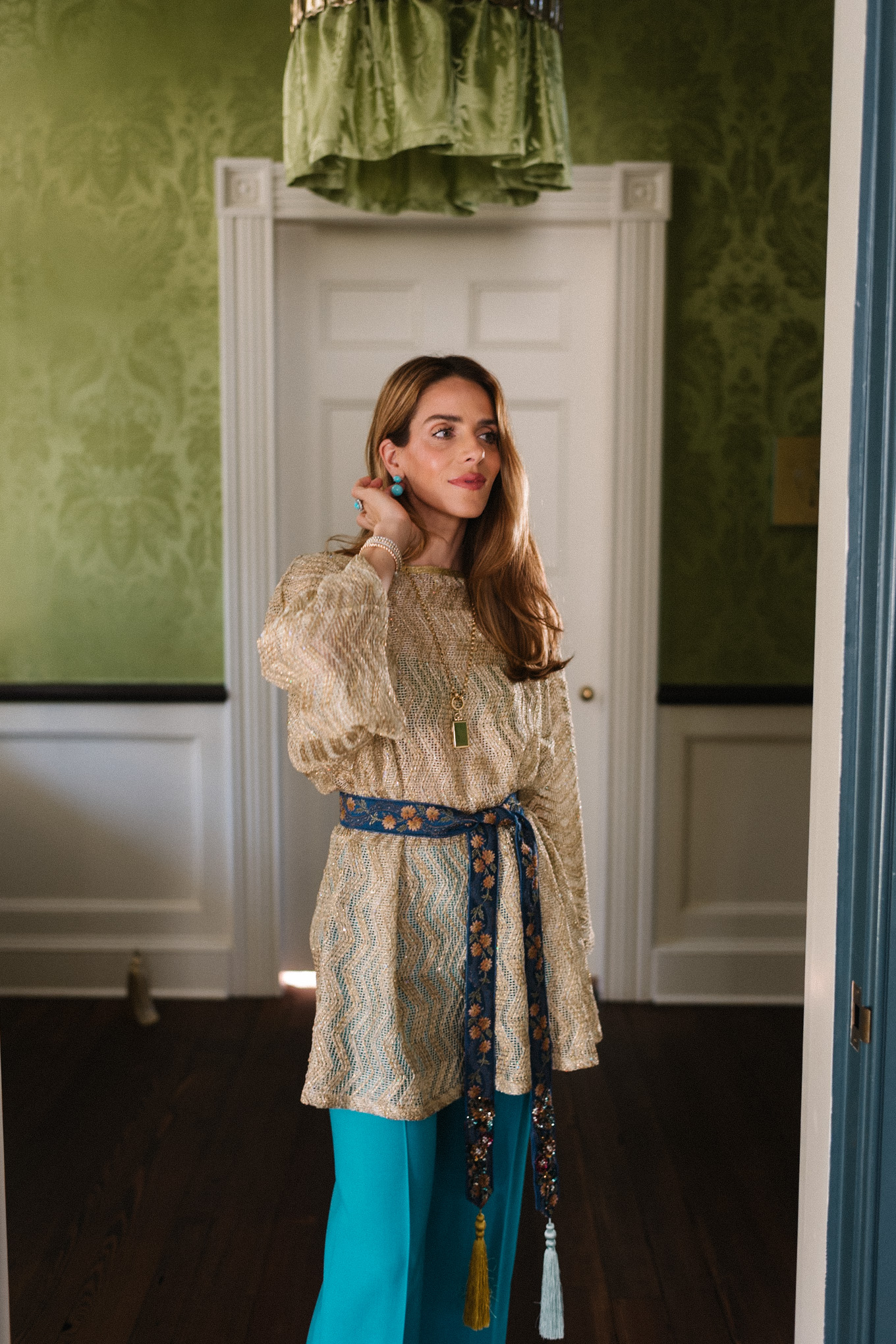 Haut en maille métallisée, pantalon en soie turquoise, ceinture à nouer en soie