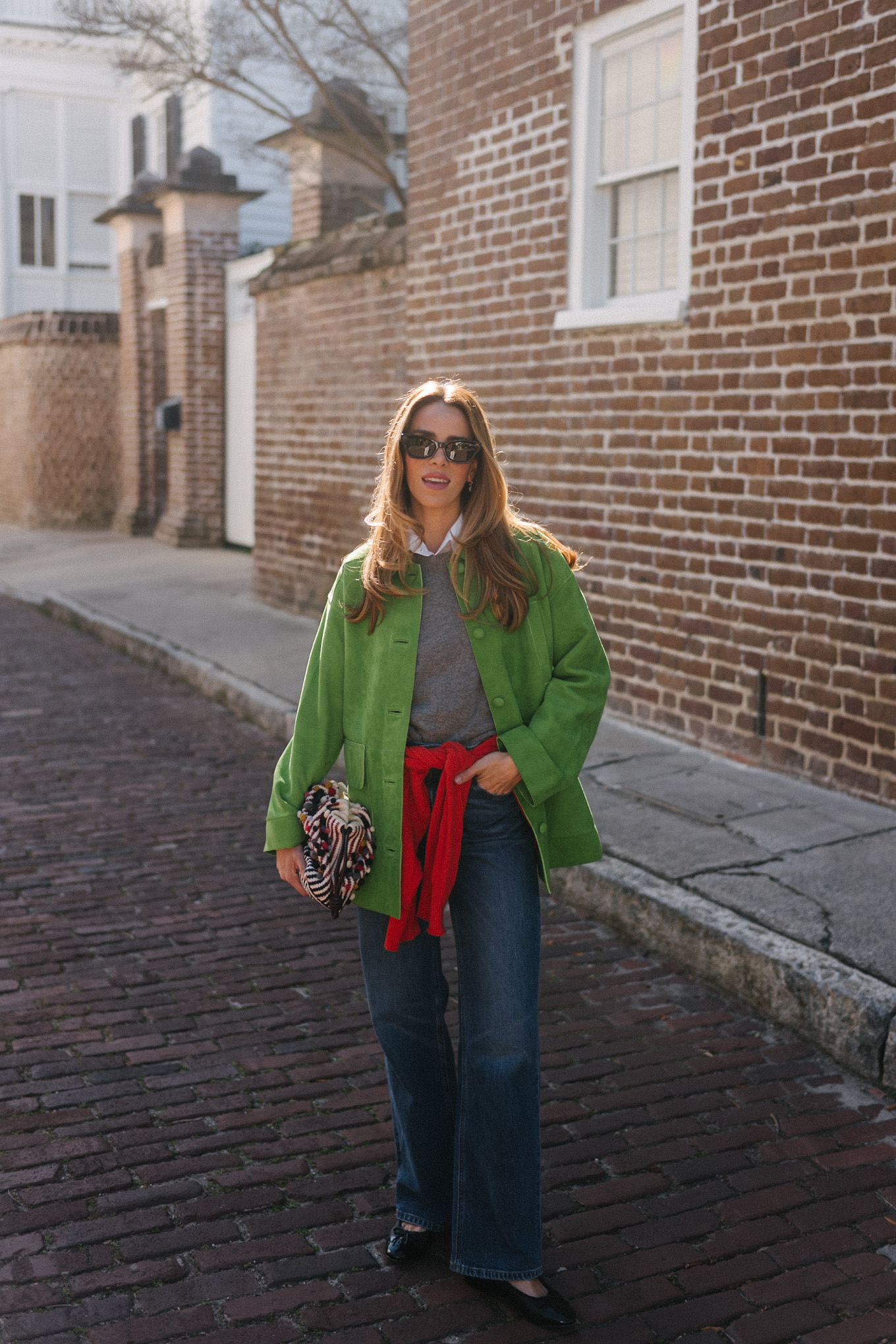 Veste en daim vert, pull en laine gris, pull en cachemire rouge, jean large, ballerines noires