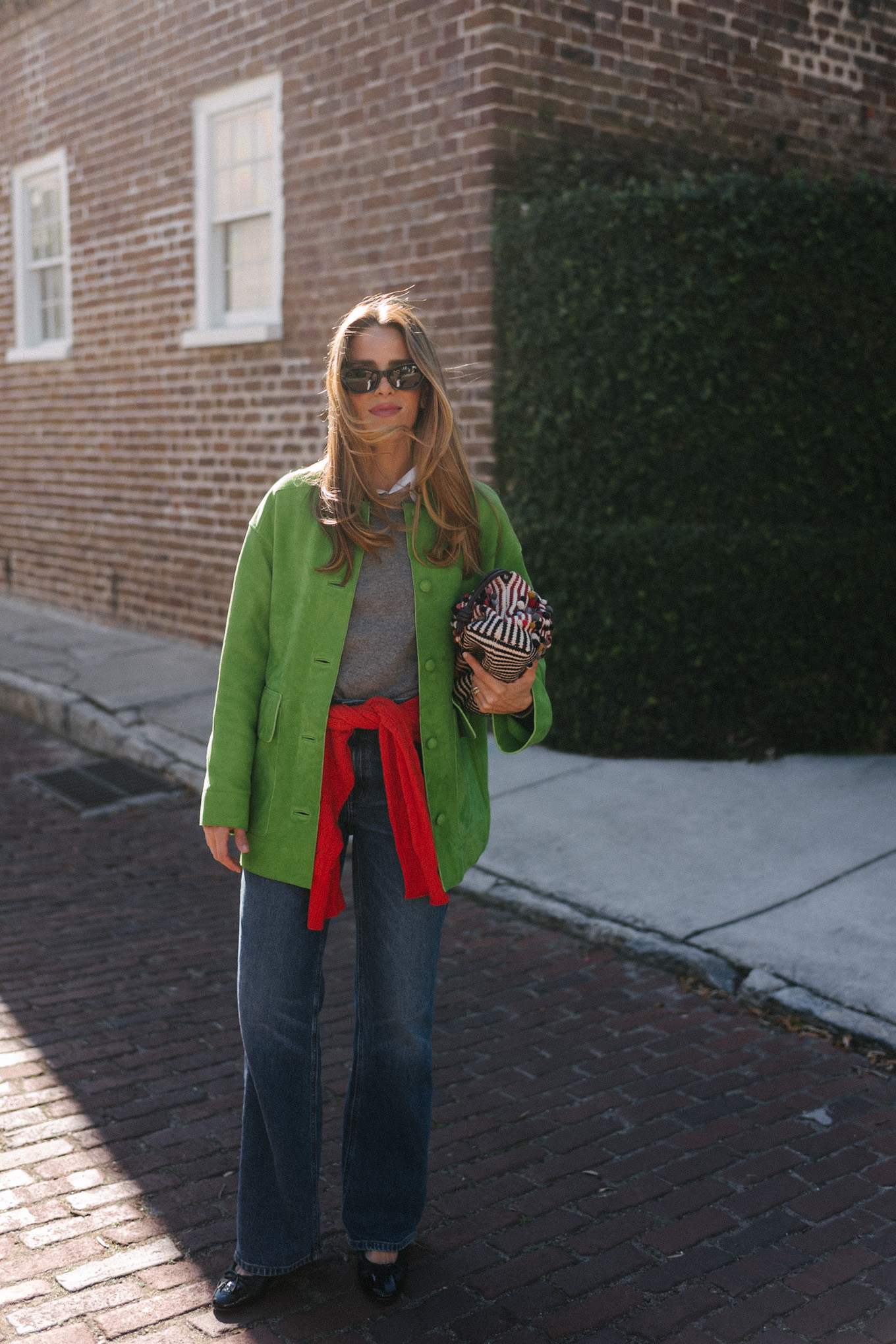Veste en daim vert, pull en laine gris, pull en cachemire rouge, jean large, ballerines noires