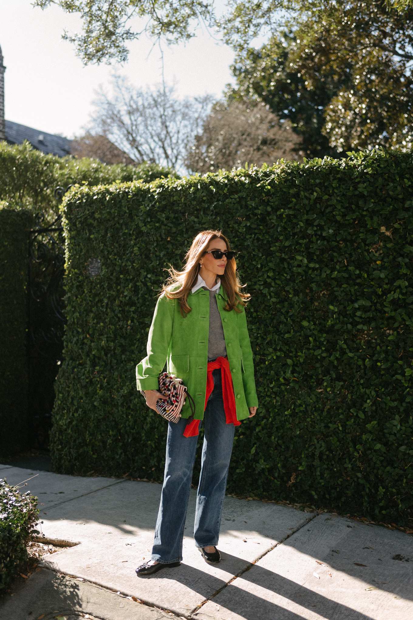 Veste en daim vert, pull en laine gris, pull en cachemire rouge, jean large, ballerines noires
