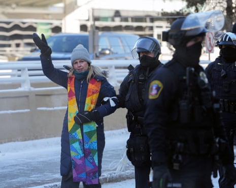 A police officer detains a clergy member as protests continue against the surge of federal immigration agents in Minneapolis, Minnesota. 23 January 2026.