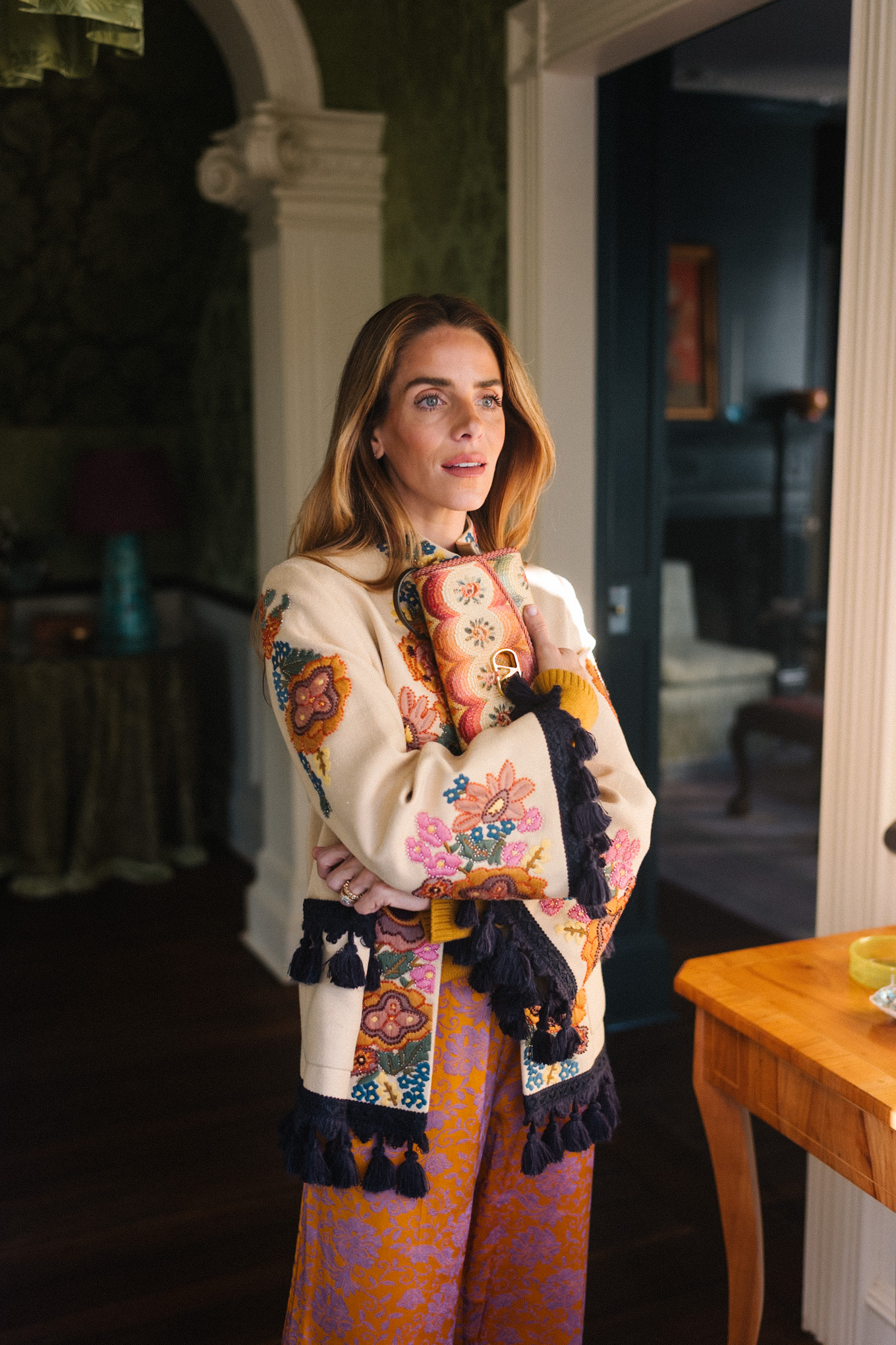 Veste brodée à pompons, pantalon en soie, sac à main brodé