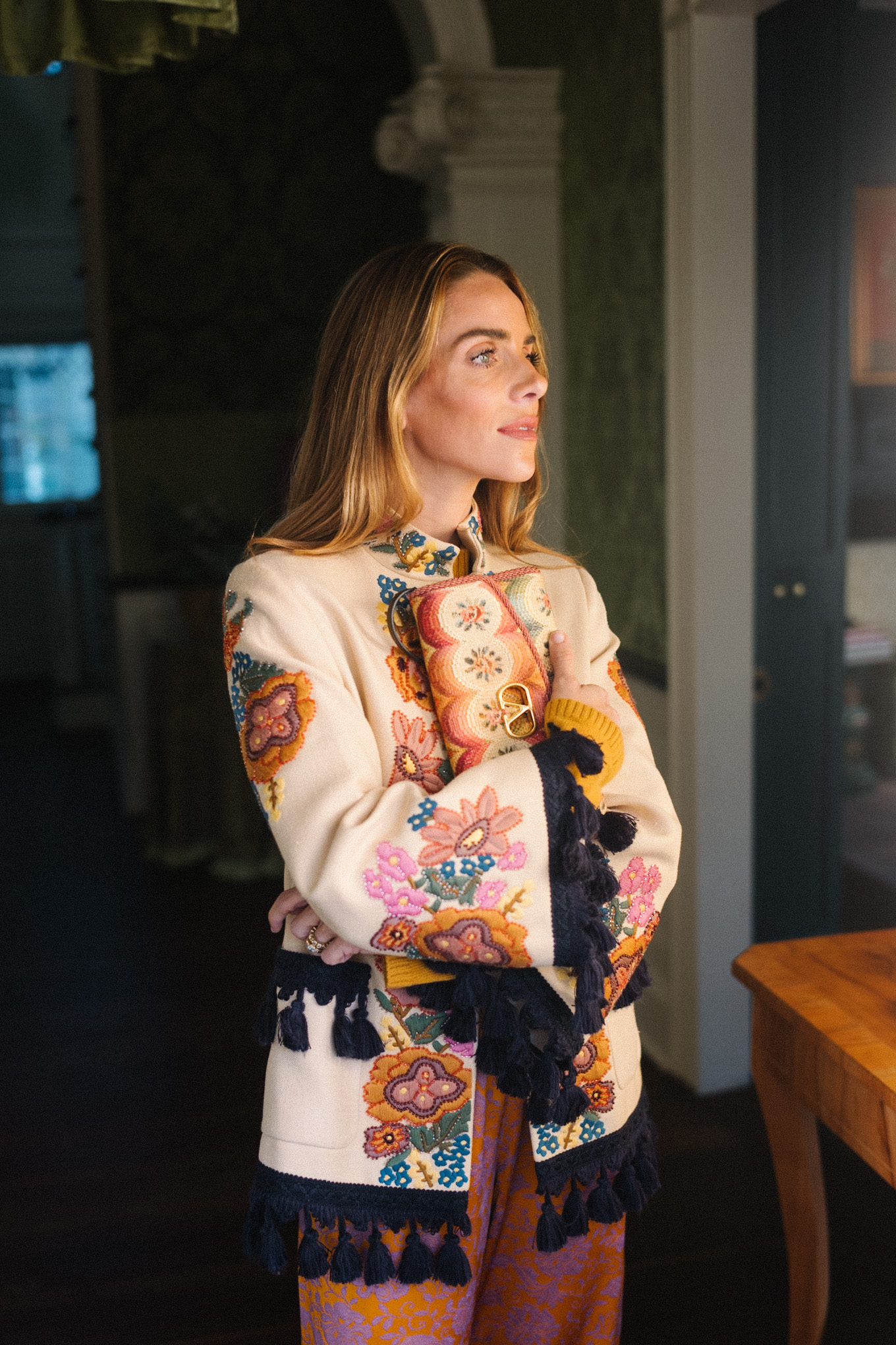 Veste brodée à pompons, pantalon en soie, sac à main brodé