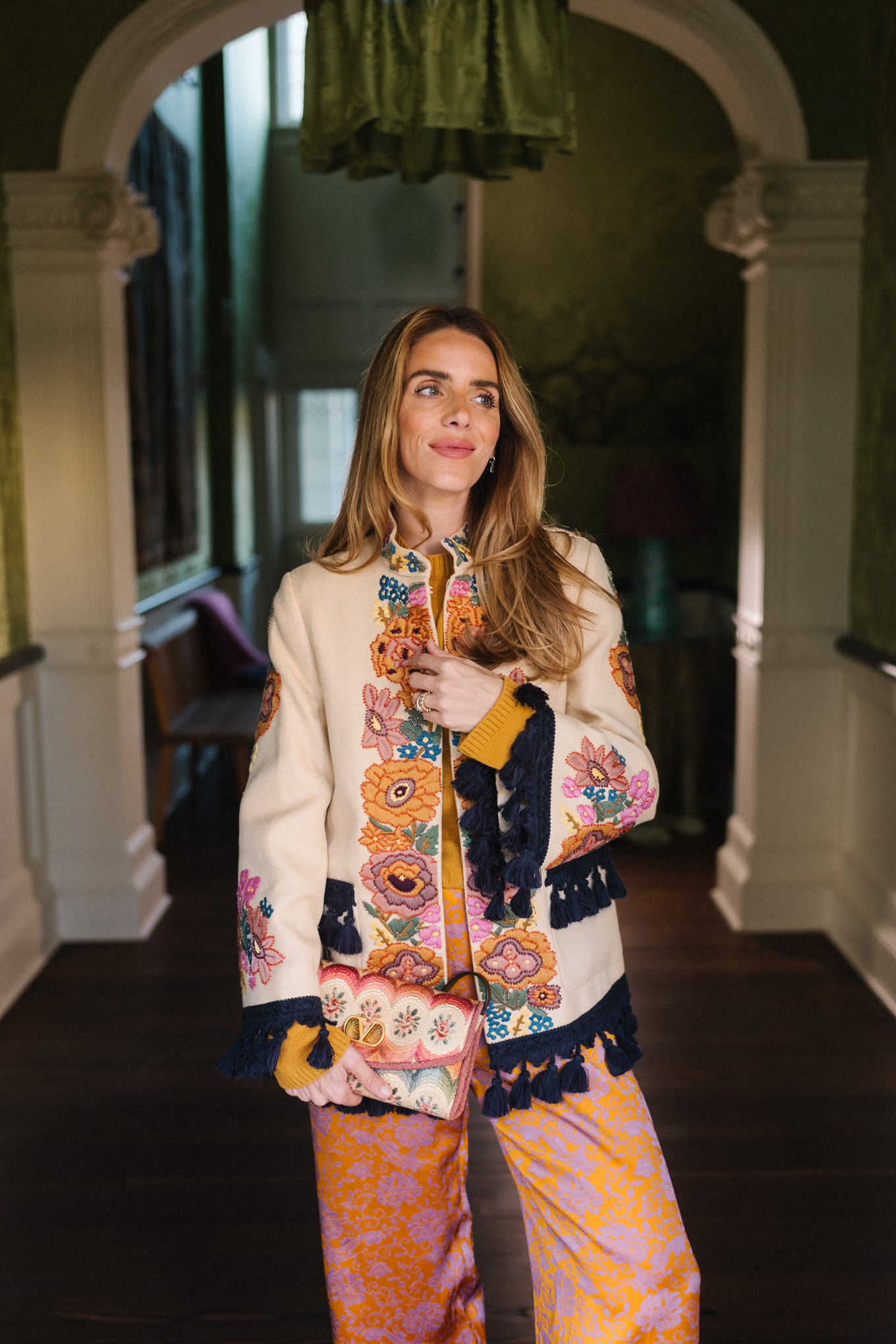 Veste brodée à pompons, pantalon en soie, sac à main brodé
