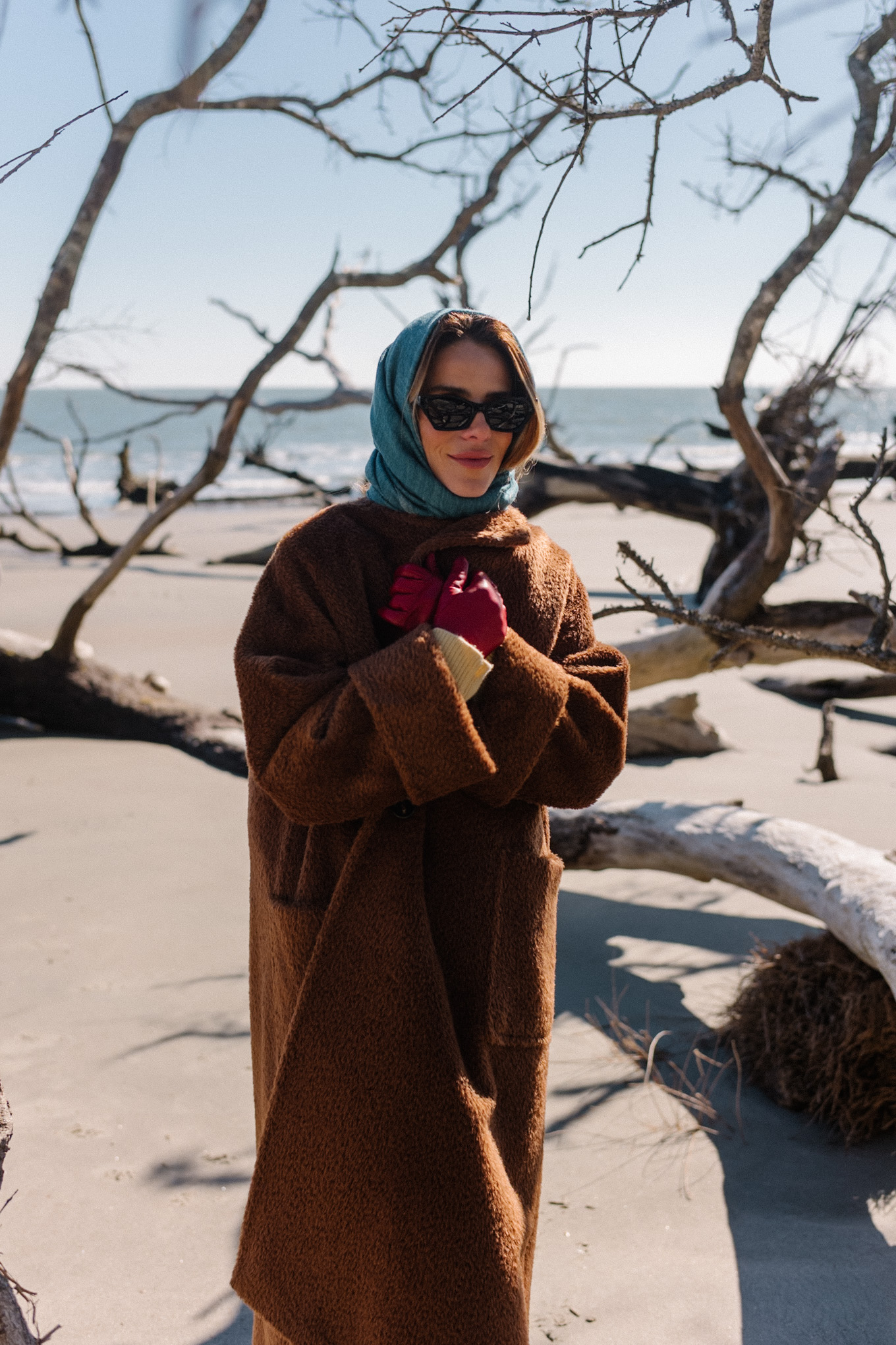 Manteau polaire surdimensionné marron, écharpe bleue, pull jaune, jean crème, bottes marron