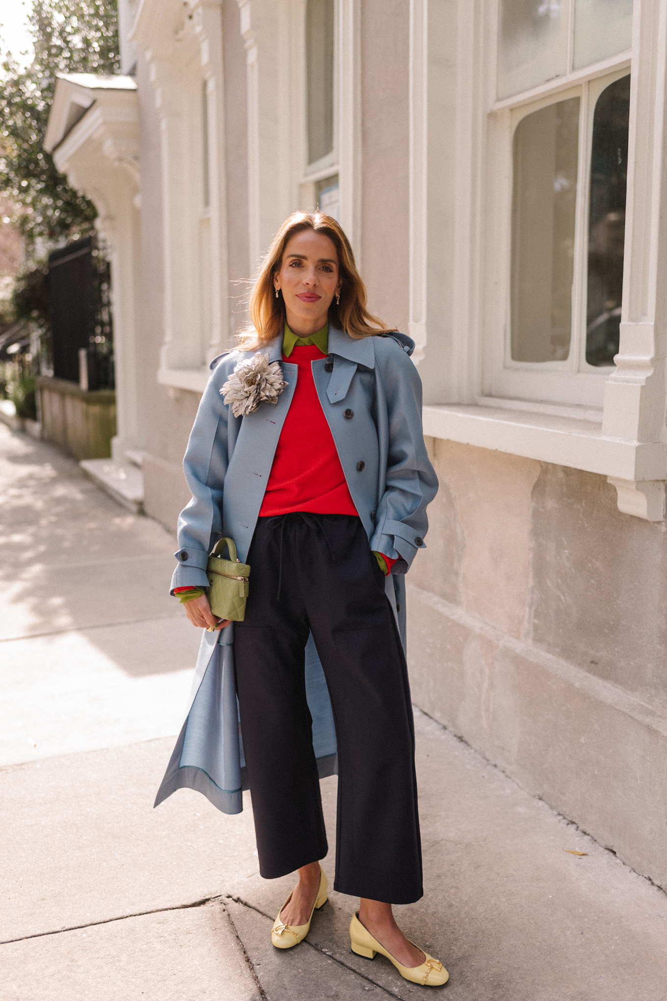 manteau en laine bleu, pull rouge, chemisier vert, ballerines jaunes, broche fleur