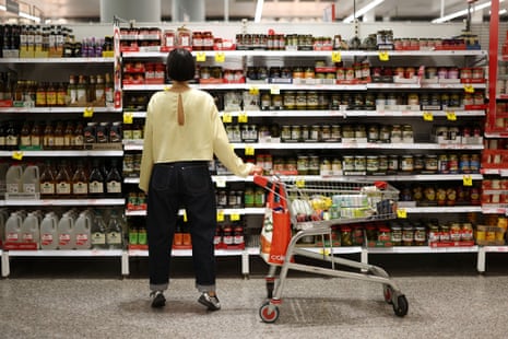 A shopper looks at items displayed on a shelf at Coles