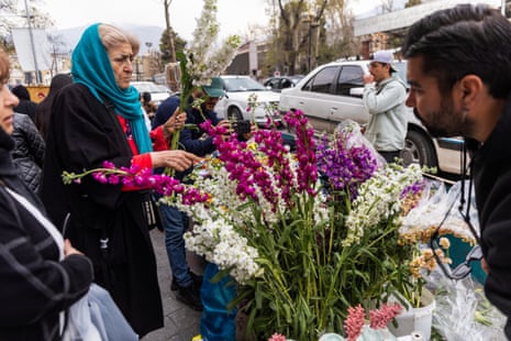 Eine Frau kauft auf einem Markt Blumen ein, um sich auf die Nowruz-Feierlichkeiten am 19. März 2026 in Teheran, Iran, vorzubereiten.