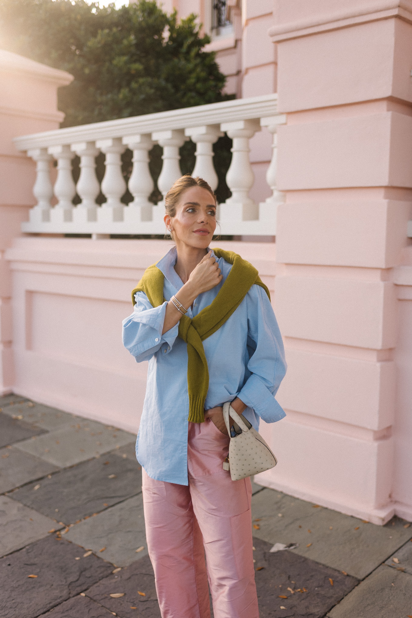 Pull boutonné chartreuse bleu clair, pantalon en taffetas rose, ballerines en velours