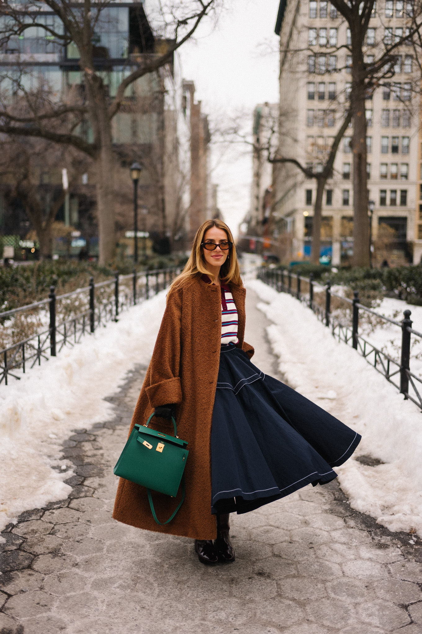chemise à col rayé, manteau en peluche marron, jupe longue bleu marine, bottes d'équitation en cuir