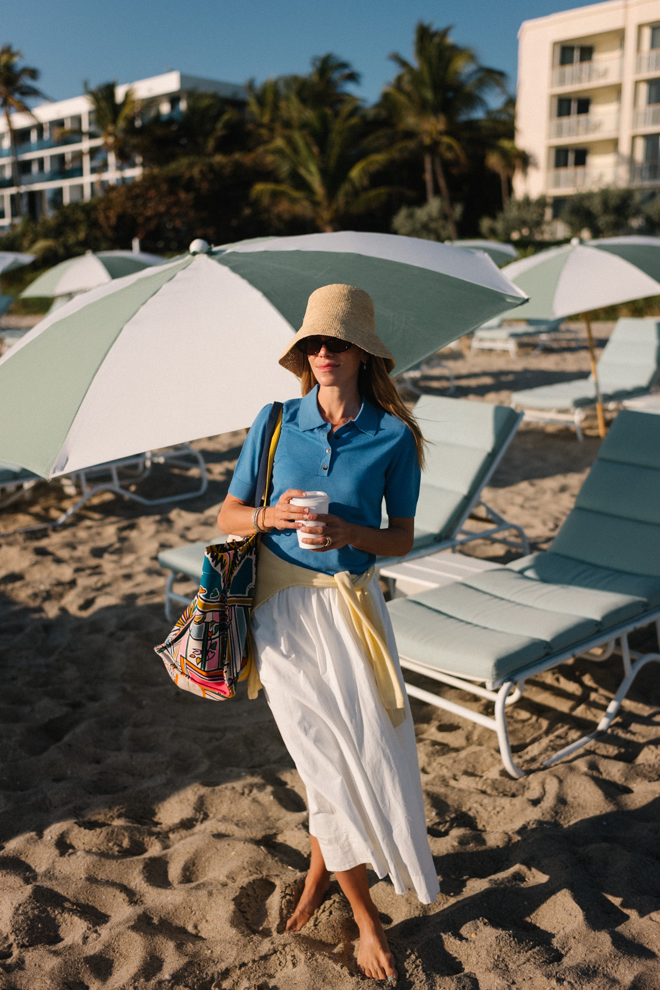 Pull bleu à col à manches courtes, pull jaune, jupe longue blanche, chapeau bob en raphia
