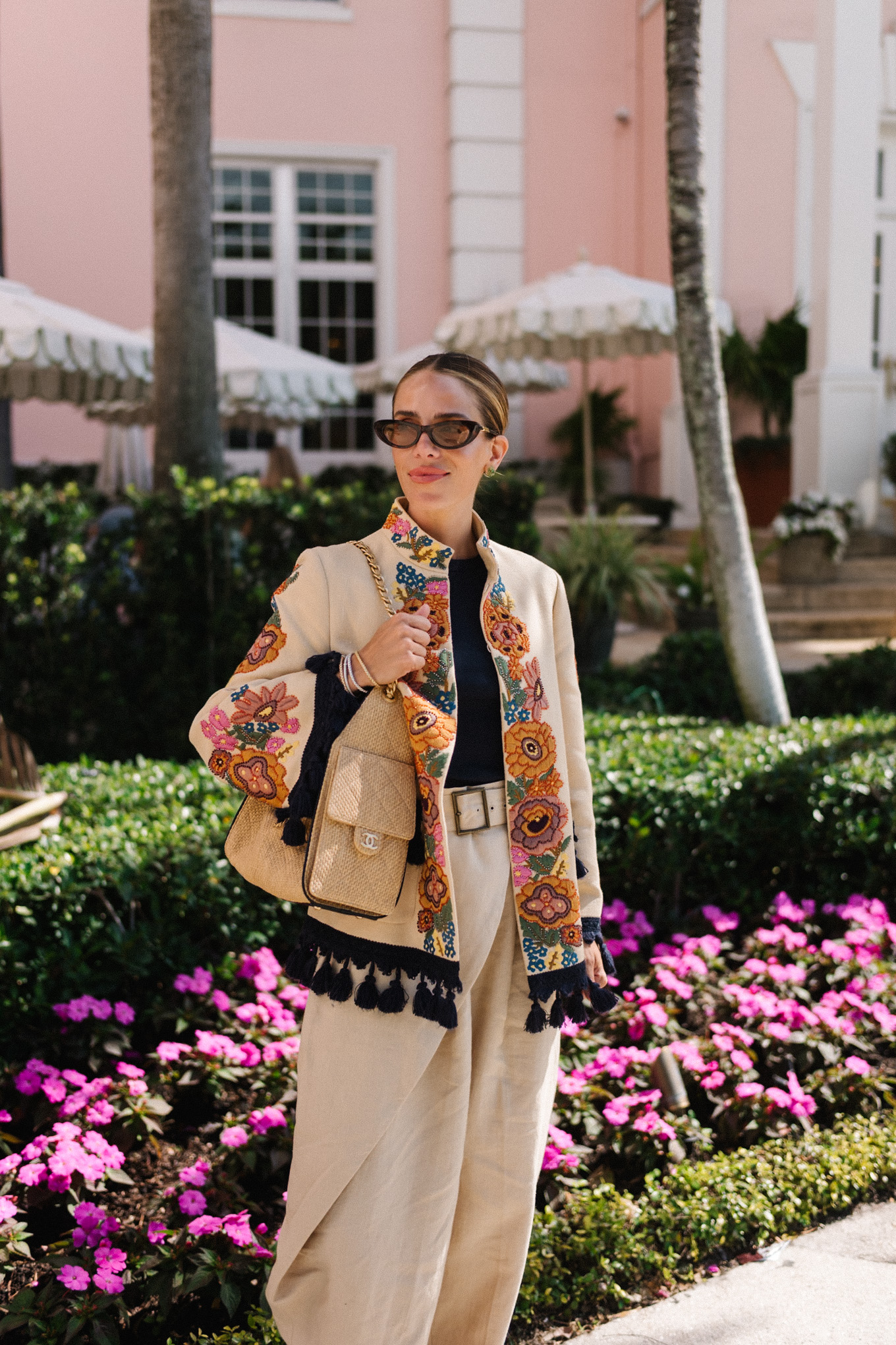 veste brodée, t-shirt noir, pantalon large en lin, sandales à lanières en cuir marron