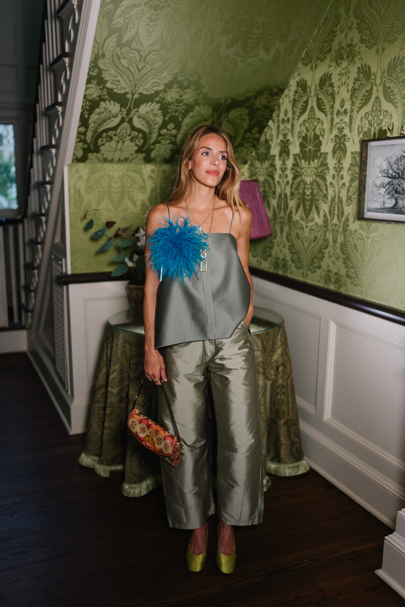 Débardeur vert, pantalon en taffetas vert, broche plume bleue