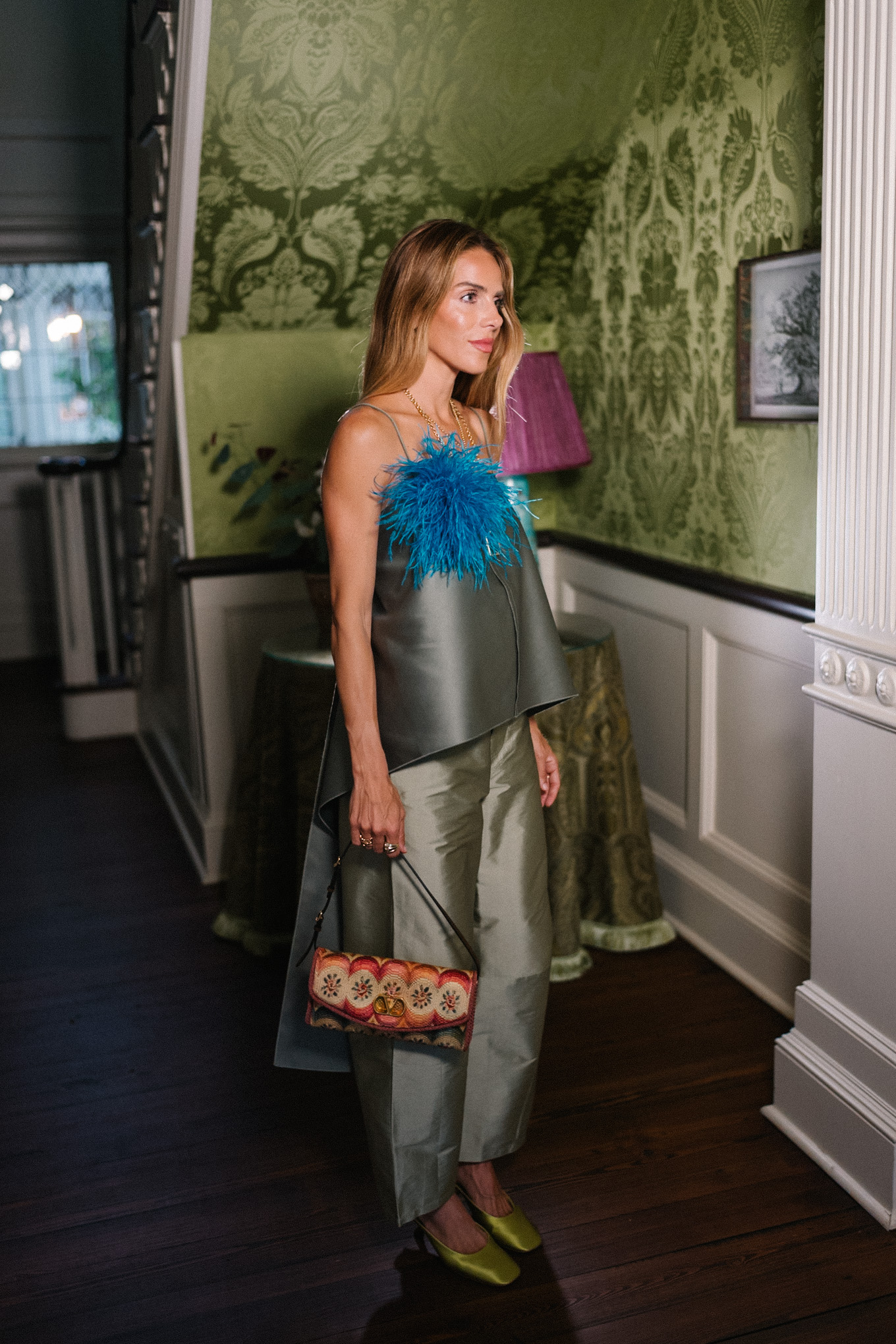 Débardeur vert, pantalon en taffetas vert, broche plume bleue