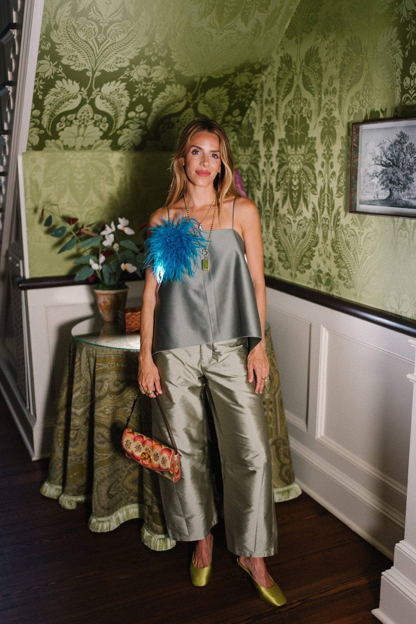 Débardeur vert, pantalon en taffetas vert, broche plume bleue