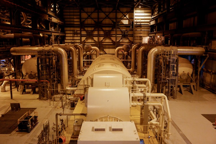 An industrial room filled with pipes and large structures.