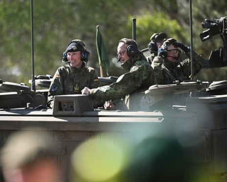 German chancellor Friedrich Merz (C) and the Inspector of the Army Christian Freuding (L) sit on a GTK Boxer tank at the German army barracks in Munster, northern Germany.