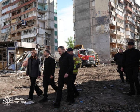 Le président ukrainien Volodymyr Zelensky, ainsi que le Premier ministre Ioulia Svyrydenko et le ministre de l'Intérieur Ihor Klymenko, visitent le site d'un immeuble résidentiel endommagé lors de l'attaque de missiles et de drones russes hier à Kiev, en Ukraine.