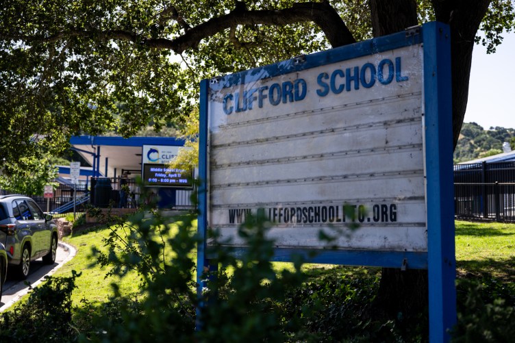 Ein Schulgebäude mit einem Schild davor mit der Aufschrift „Clifford School“.