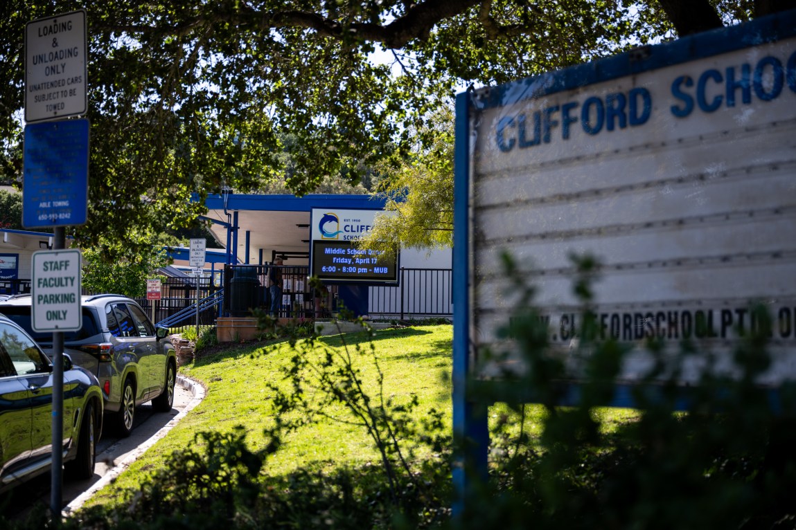 A school building with a sign in front of it that reads, “Clifford School.”