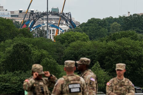 Mitglieder der Nationalgarde stehen am Fuß des Washington Monument, während in der Ferne in Washington, D.C., USA, am 27. Mai 2026 der Bau einer provisorischen Arena zu sehen ist, in der im Juni auf dem South Lawn des Weißen Hauses die UFC Freedom 250-Kampfkarte ausgetragen wird.