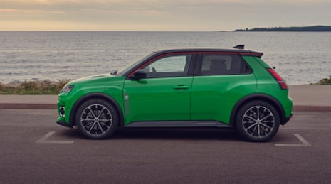 A Renault 5 electric car parked by the sea.