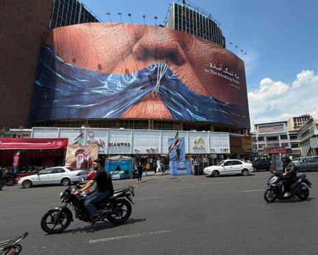 Des véhicules sont passés devant un panneau publicitaire avec une image du détroit d'Ormuz et des lèvres cousues de Donald Trump sur une place du centre de Téhéran, en Iran, ce week-end.