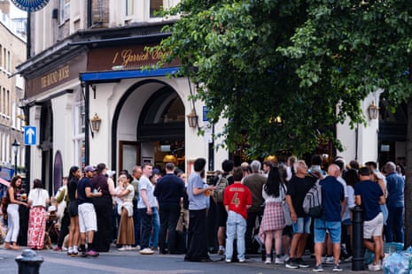Crowds of people gathered outside a pub.