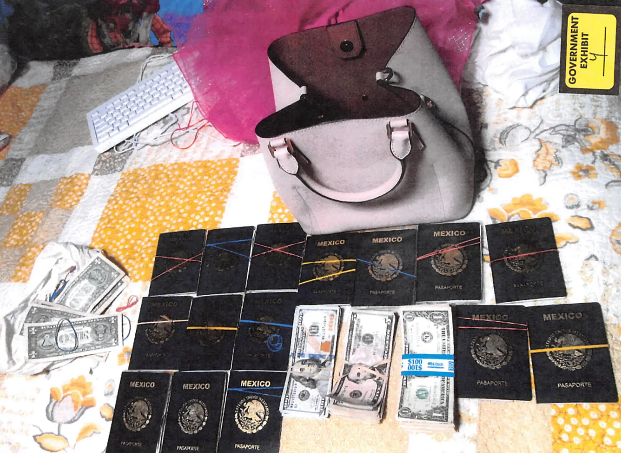 Quinze passeports mexicains et des piles de devises américaines sur une couverture patchwork devant un sac à main rose.