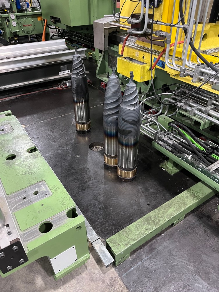 Three deformed artillery shells on a factory floor.