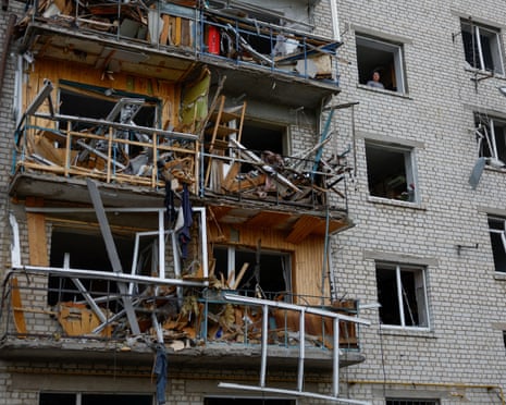A woman looks out of a window of her apartment damaged by a Russian missile strike in the town of Boryspil, amid Russia’s attack on Ukraine, in Kyiv region, Ukraine.
