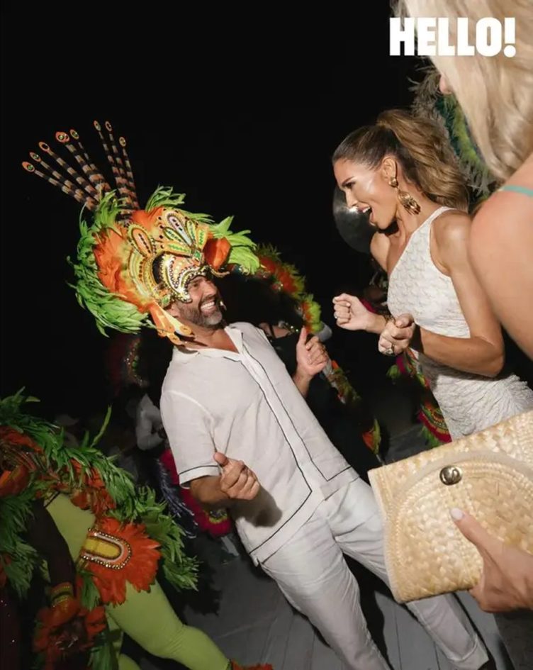 Donald Trump Jr. wears a multi-colored Junkanoo headpiece while dancing with Bettina Anderson.