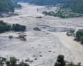 People wading through the mud-filled river valley in Betrawati