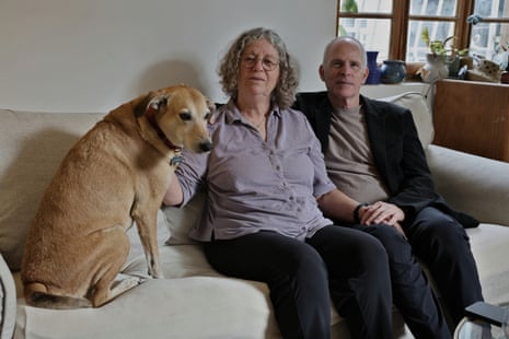 Keith and Aviva Siegel sitting on their sofa with their dog.