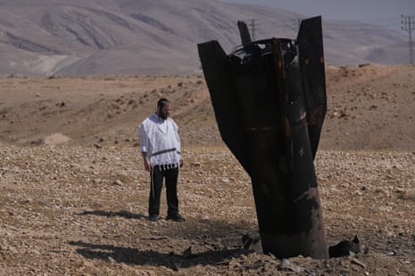 A man looks at the wreckage of an Iranian missile that landed near the West Bank city of Jericho in June.