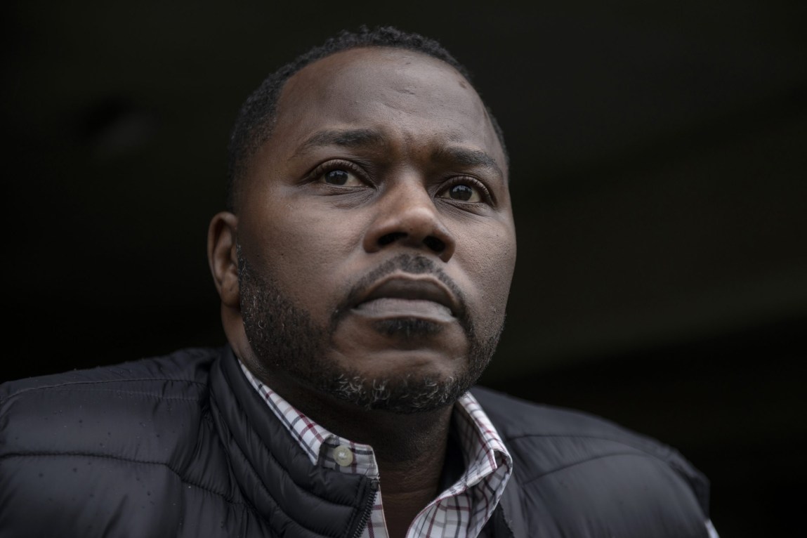 A close-up photo of a man with a serious expression.